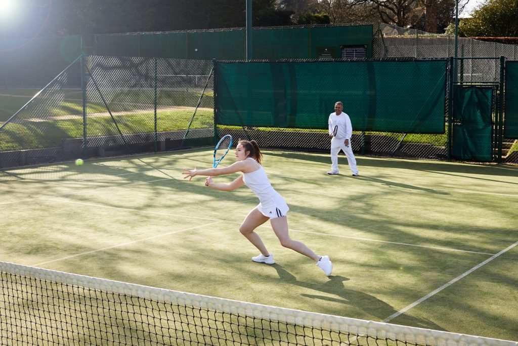 Lady playing tennis courts at St George's Hill Lawn Tennis Club Surrey